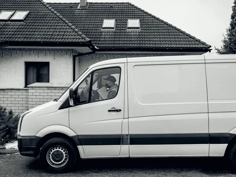 Weißer Transporter vor einem Wohnhaus